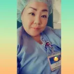 Woman poses for a selfie in full scrubs and cap